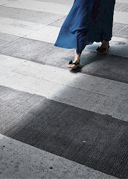 Foto von Frauenfüßen, die eine Straße überqueren